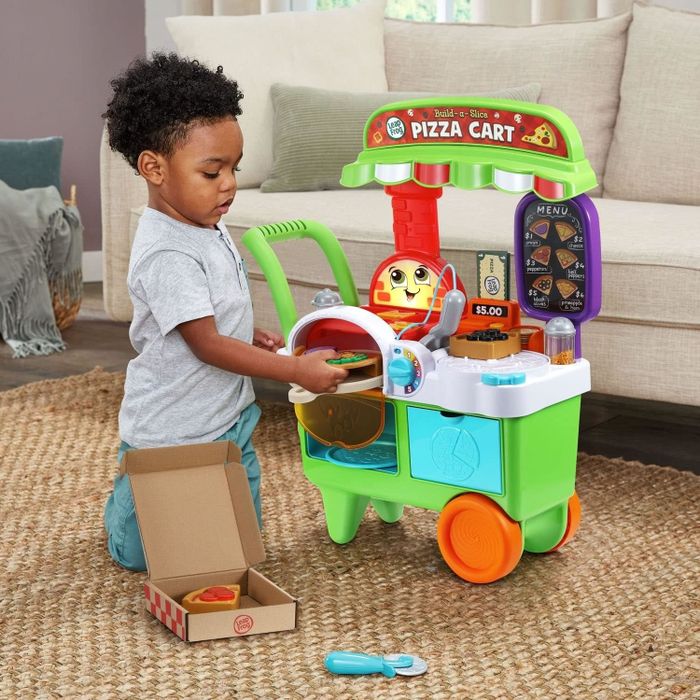 A child engaging with a pizza cart toy