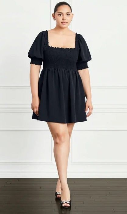 a model in a puff-sleeve babydoll dress in black