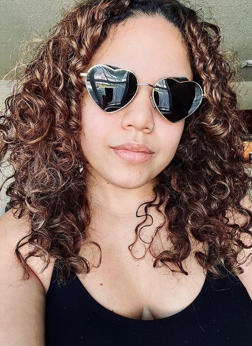 reviewer wearing heart-shaped sunglasses with black lenses