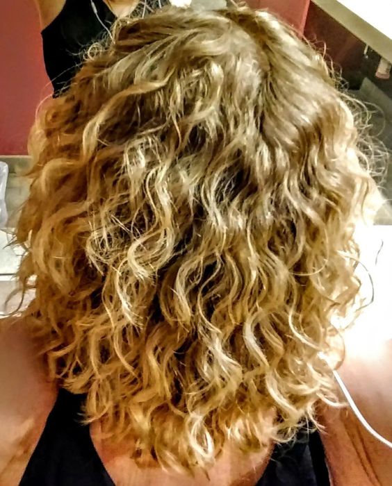 Back view of a reviewer with blonde curly hair, wearing a black tank top.