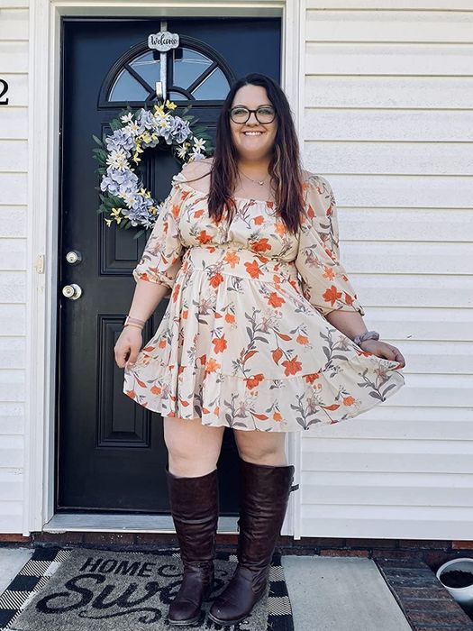 A reviewer wearing the floral dress