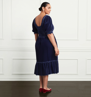 The same model presenting the back view of the dress.