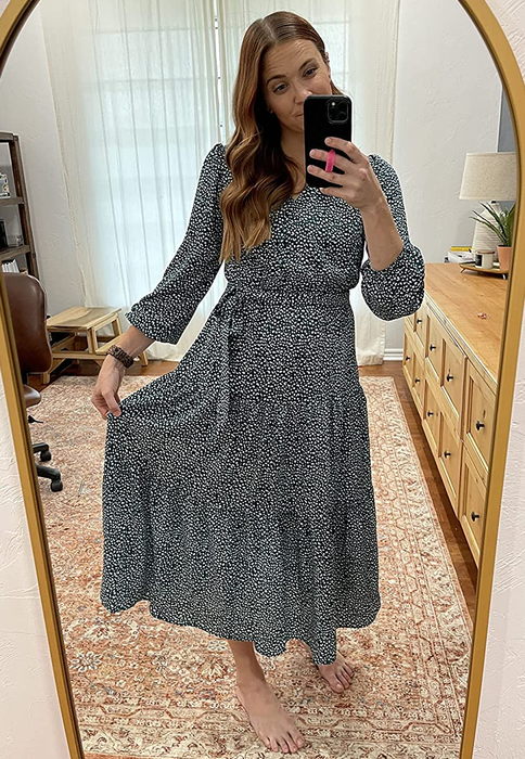 a reviewer modeling the long-sleeve midi dress in blue with white polka dots