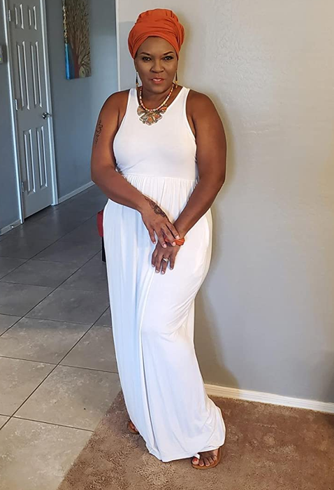a reviewer wearing a bright orange headscarf paired with the white maxi dress