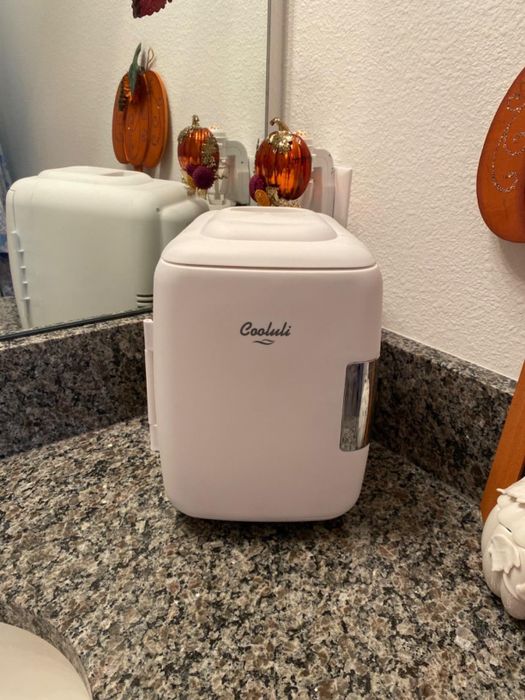A reviewer’s image shows the mini beauty fridge in a sleek white design.