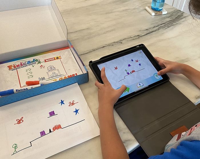 A child’s drawing, followed by them playing the animated version of it on an iPad.