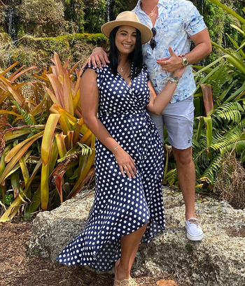 A reviewer in a navy blue V-neck dress adorned with white polka dots