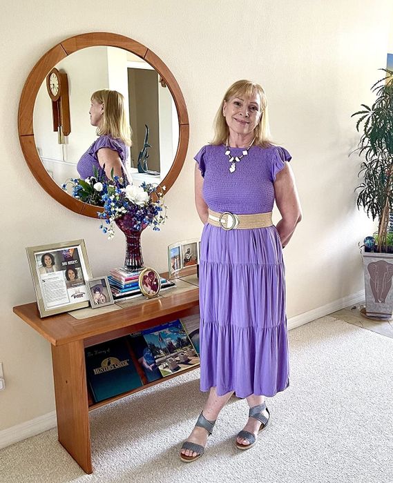A reviewer flaunting the dress in purple