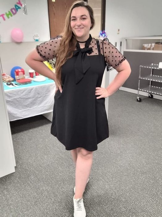 A reviewer wearing the little black dress with mesh sleeves adorned in polka dots