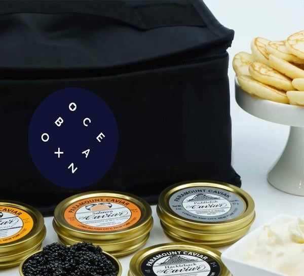 carrier bag with tins of caviar, creme fraiche, and blinis