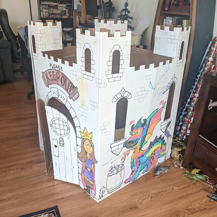 A reviewer showing the cardboard fairytale castle their kids colored in
