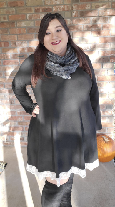 A reviewer in a black dress with white trim