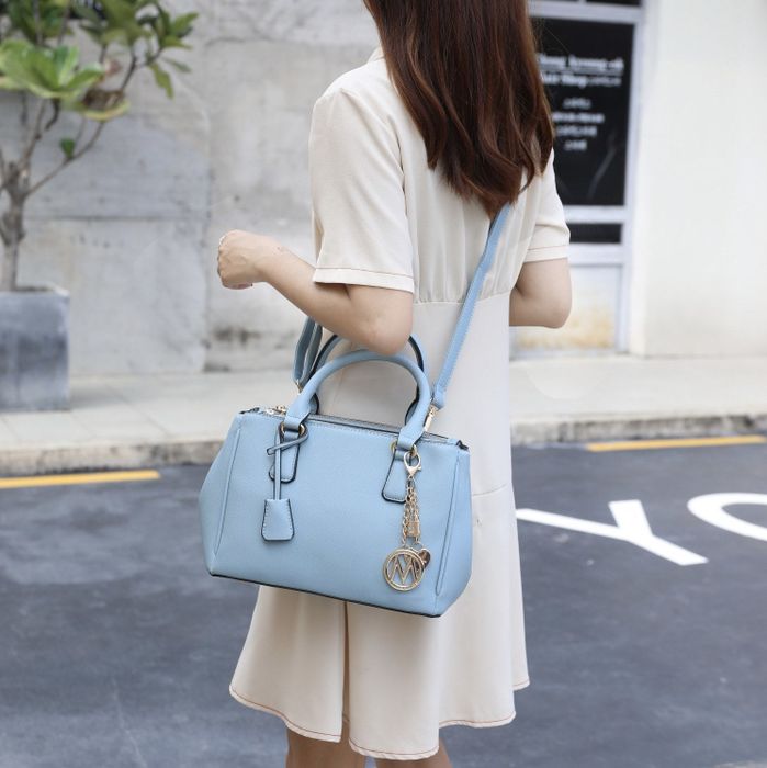 Model carrying the blue handbag as a crossbody