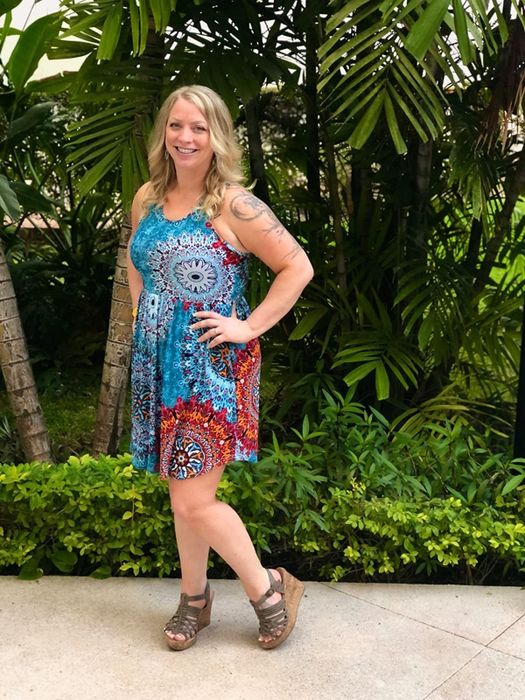 A reviewer wearing the blue and red printed dress