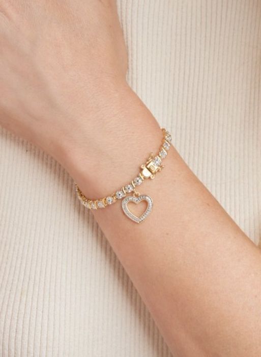 The gold bracelet fastened onto a wrist