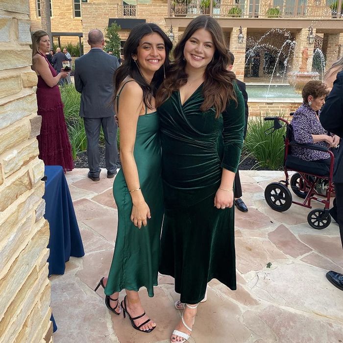 A reviewer wearing the long-sleeve velvet dress in a beautiful green hue.