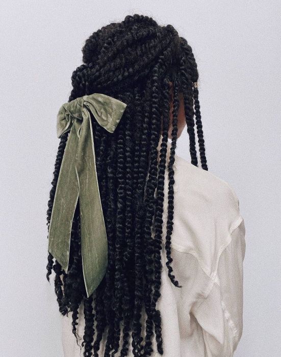 Model sporting a green bow in black hair