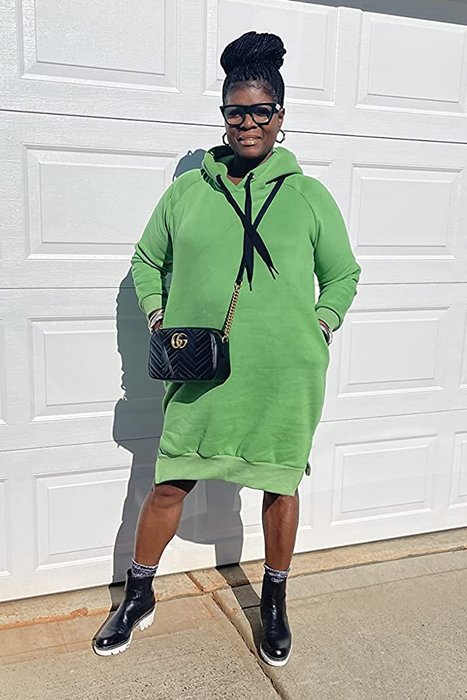 a reviewer wearing the hooded midi dress in green