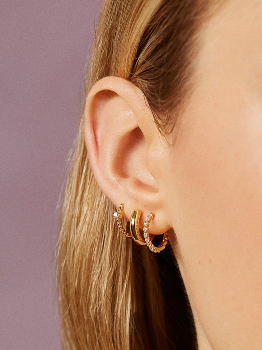 Model showcasing all three pairs of earrings in their ear.