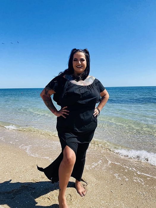A reviewer wearing the dress in black