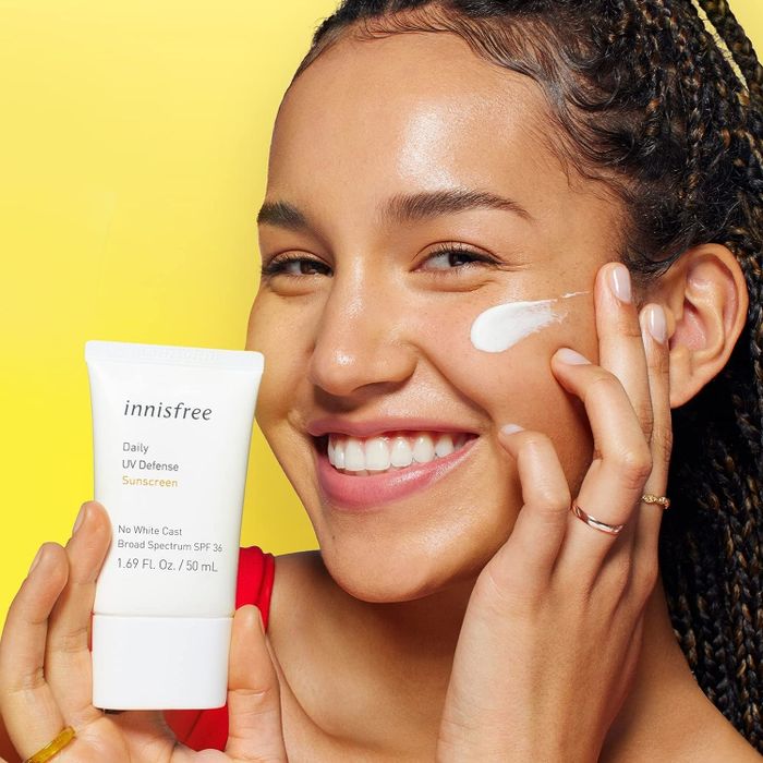 model holding and applying sunscreen