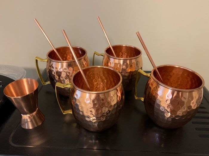 A reviewer image showcasing the four mugs, straws, and jigger included in the set.