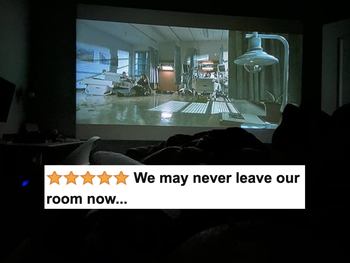 A reviewer's photo of their projector casting a movie on their bedroom wall.
