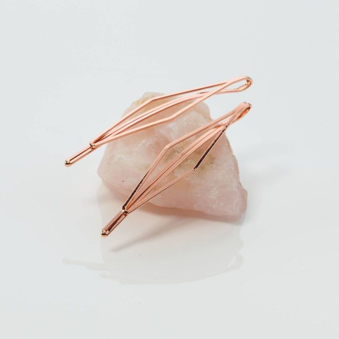 Rose gold bobby pins alongside a chunk of rose quartz