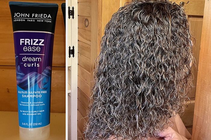 Image of a blue, purple, and black shampoo bottle placed on a white counter, showing the reviewer's tightly curled brown hair after using the product, standing in front of a wooden door.