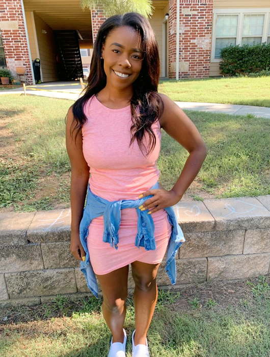 A reviewer in a light pink midi bodycon tank dress