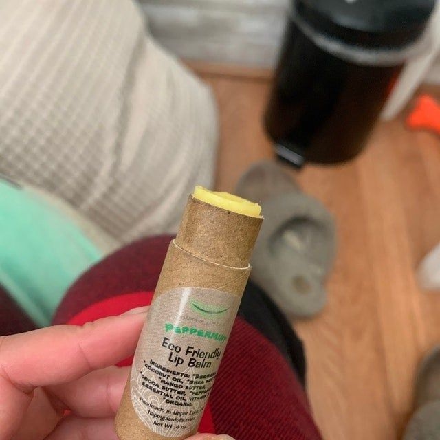 A reviewer holding one of the lip balms