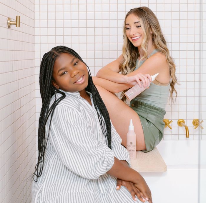 Two models posing with bottles of the rinse