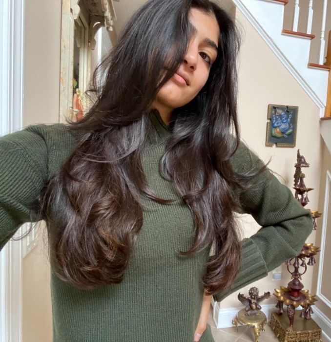 A reviewer showing the results of their hair after using the blow-drying brush