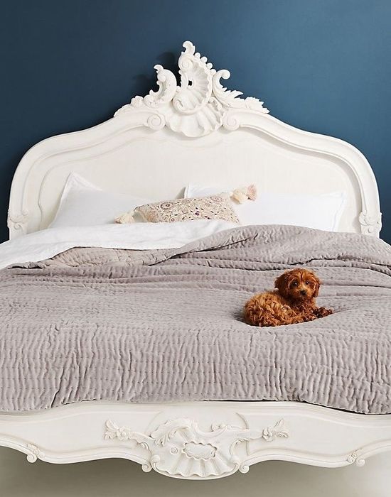 Intricately carved bed frame featuring royal filigree details on the headboard and baseboard