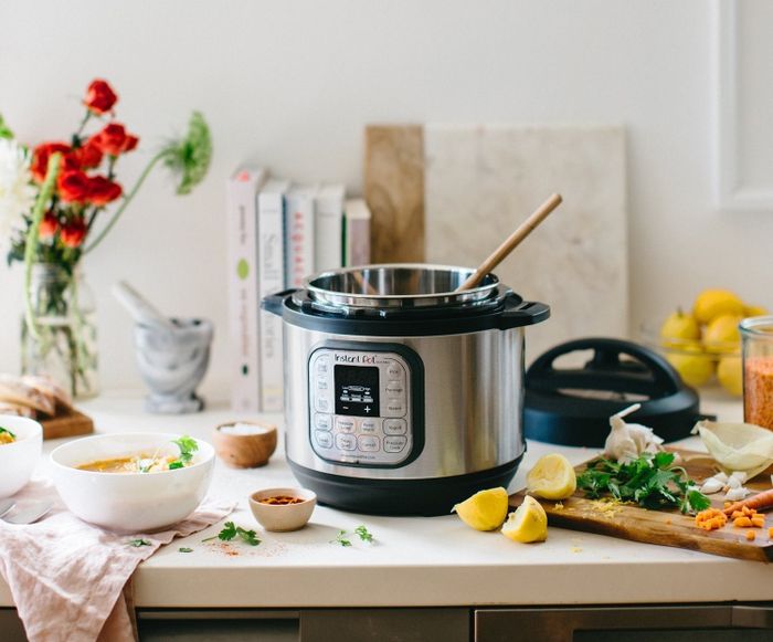 The Instant Pot featuring a sleek silver exterior with a black base and handles, complete with a user-friendly interface on the front.