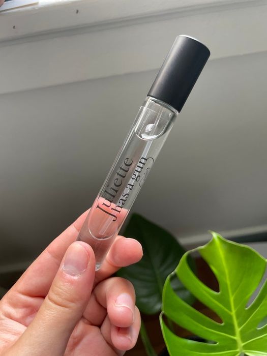 writer holding a small travel-sized bottle of the fragrance spray