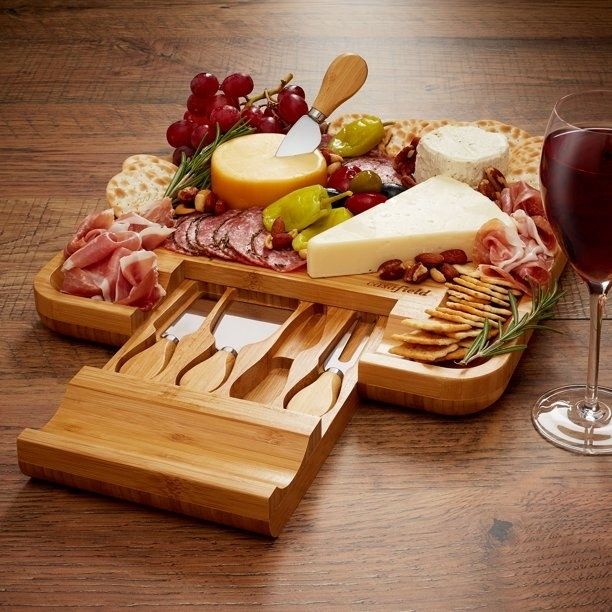 the bamboo tray with the utensil drawer extended, showcasing cheese, cured meats, and crackers on top