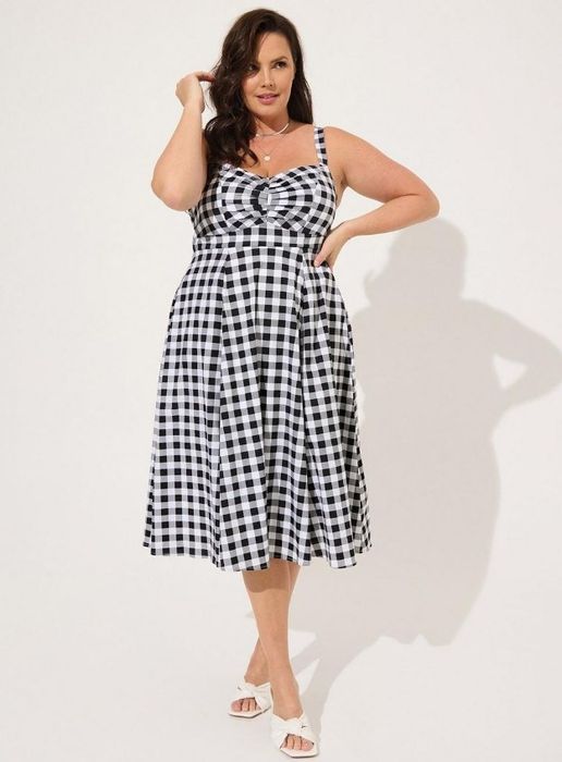 A model in a black gingham midi dress