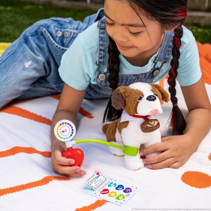 A child playing with a check-up kit designed for Elf on the Shelf plush dolls