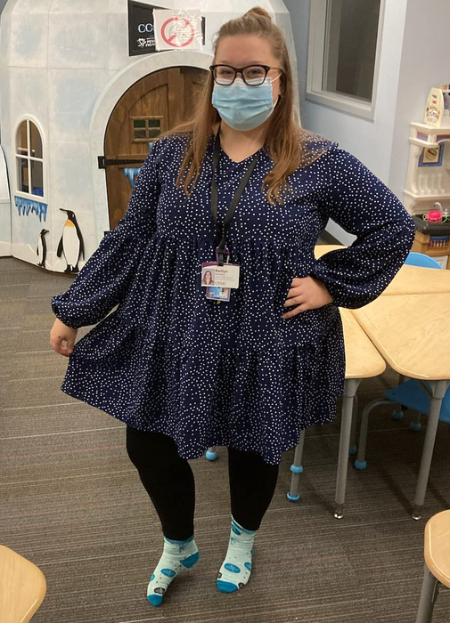 a reviewer wearing the long sleeve dress in navy blue adorned with white polka dots