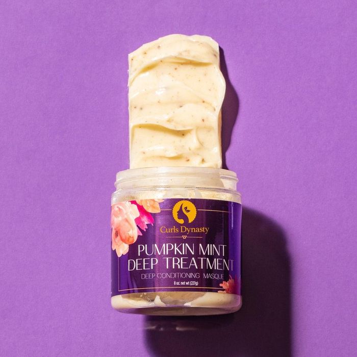 A tub of the pumpkin and mint masque, with a dollop of the product swirled out of the container