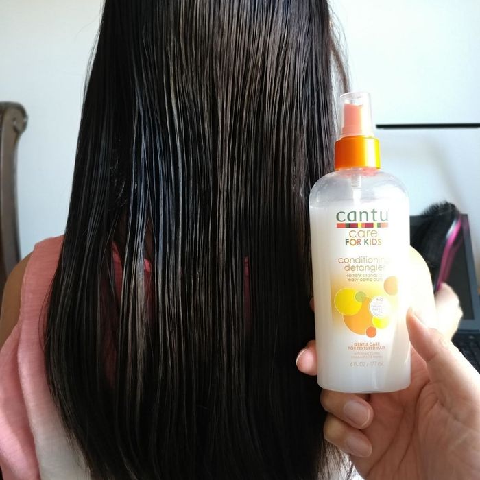 A reviewer's photo showcasing smooth, frizz-free hair after applying the detangler spray