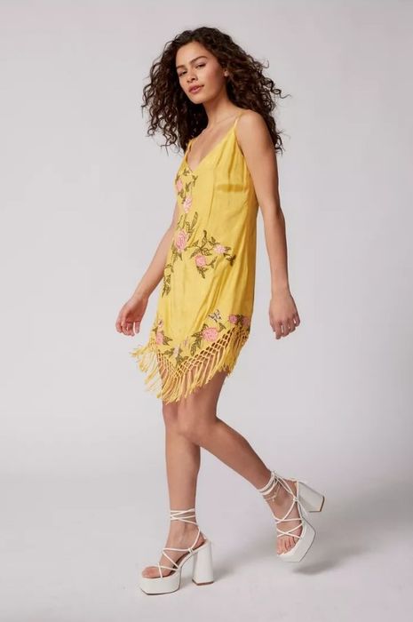 A model rocking a yellow fringe dress