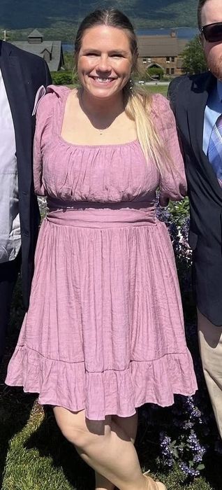 A reviewer is dressed in a purple dress