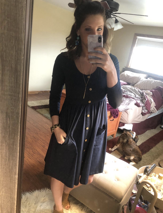 A reviewer wearing the black version of the dress