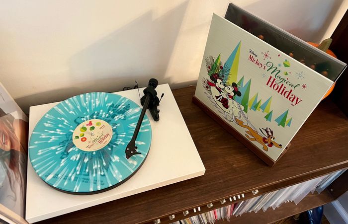 A blue-and-white splattered vinyl next to the album cover of Mickey's Magical Holiday, perfectly capturing the holiday spirit.