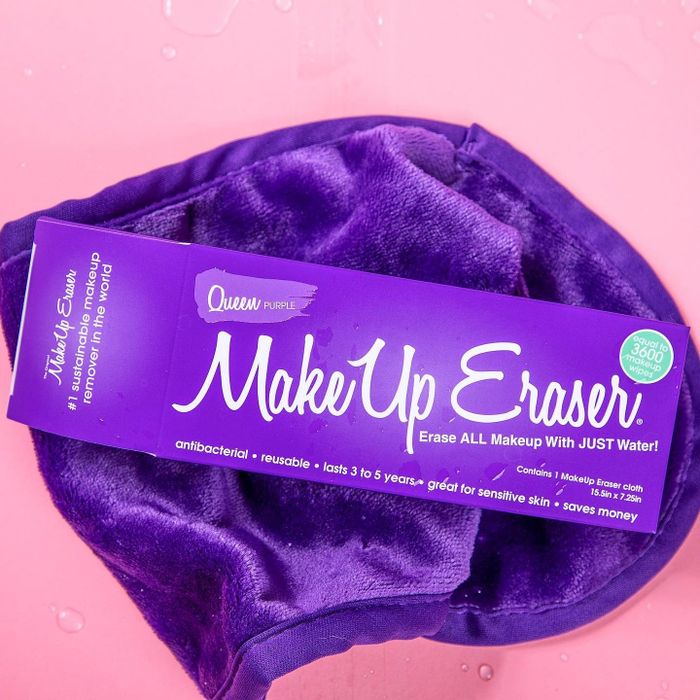 A purple makeup removal cloth alongside its packaging.