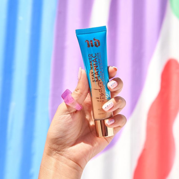 model holding a bottle of the Urban Decay hydrator