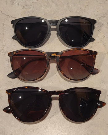 Three pairs of sunglasses showcased: black frames at the top, dark brown frames in the middle, and a tortoiseshell pattern at the bottom
