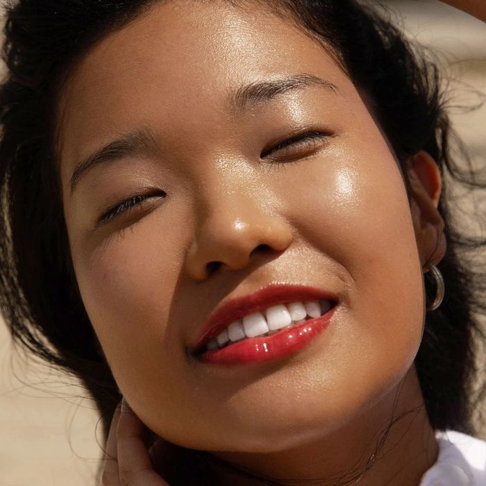 A model is seen wearing the lip gloss in a specific shade.